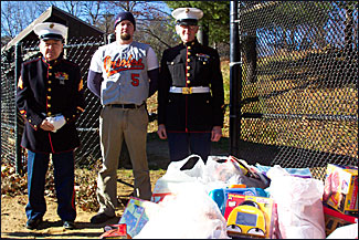 Toys for Tots representatives from the U.S. Marines, Jack McDonald and Paul Nolan, pose with Tim Fish of the MABL Orioles, who is also a 6-year veteran of the U.S. Marines