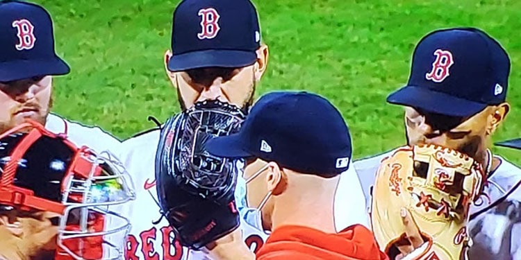 baseball players talking into their gloves